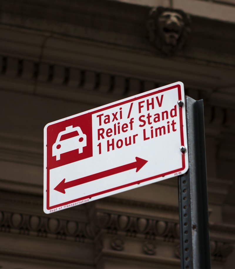 Parking sign reading Taxi / For Hire Vehicle Relief Standa 1 Hour Limit in New York City